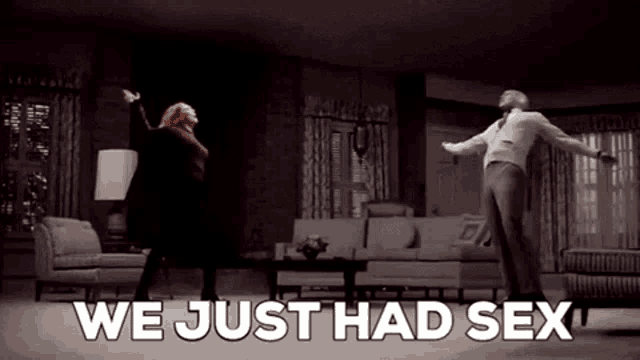 a man and a woman are dancing in a living room with the words `` we just had sex '' written on the screen .