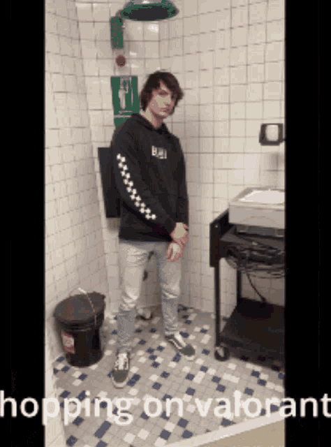 a man standing in a bathroom with the words " hopping on valorant " written on the bottom