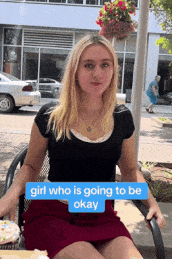 a girl in a red skirt sits in a chair with a sign that says " girl who is going to be okay "