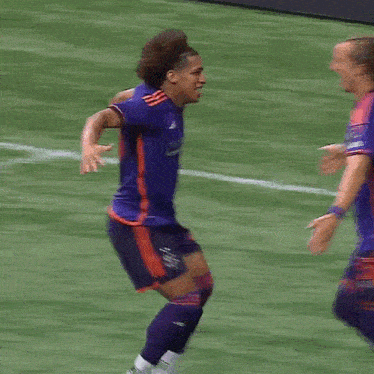two soccer players are hugging each other and one has the number 2 on her jersey
