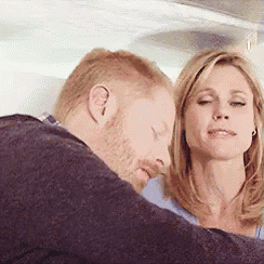 a man and a woman are sitting next to each other and the woman is looking at the man 's face .