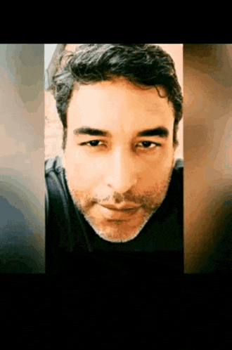 a man with a beard is looking at the camera