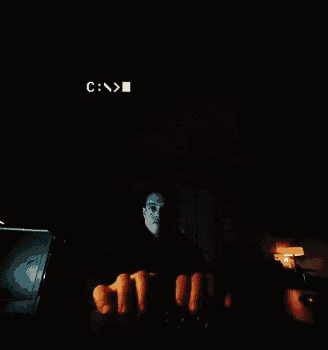 a man holds carrots in front of a computer screen that says hello again