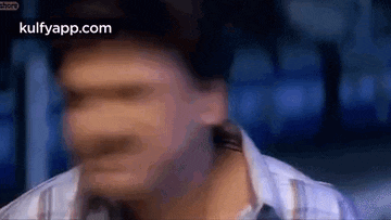 a blurry picture of a man 's face with a blue background .