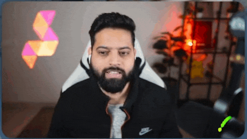 a man with a beard is sitting in a nike chair