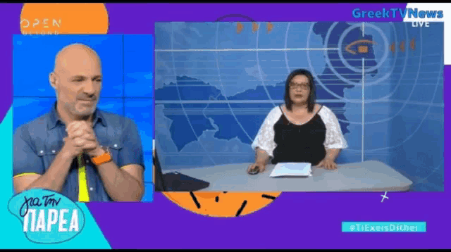 a man and a woman are sitting at a table in front of a screen that says greek tv news live