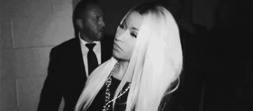 a black and white photo of a woman with long blonde hair standing next to a man in a suit .