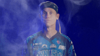 a man wearing a blue jersey that says gymnast on it