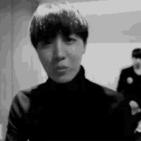 a black and white photo of a man wearing a turtleneck sweater .