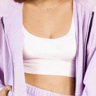 a woman is wearing a purple jacket and a white crop top