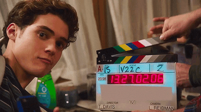 a man stands in front of a clapper board that says a15 v22c