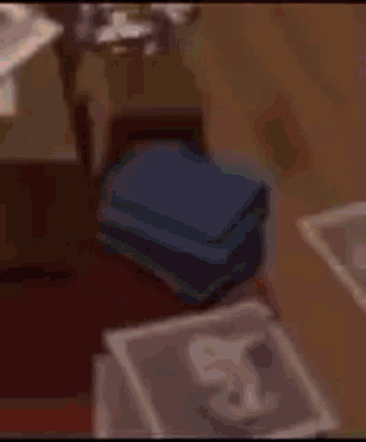 a doll with a green hat is sitting on a table in a bedroom .