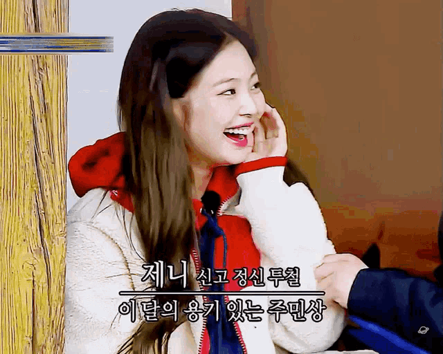 a woman in a red hoodie is smiling in a korean language