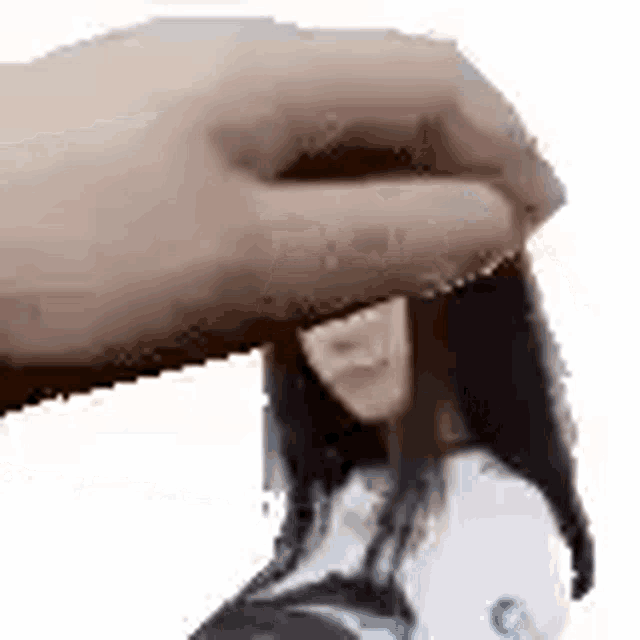 a hand is holding a woman 's head in front of her face .