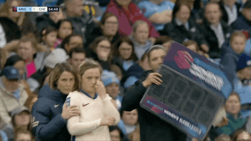 a woman holding a sign that says ' women 's world league '