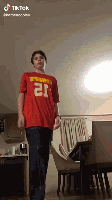 a boy wearing a red shirt that says chiefs on it