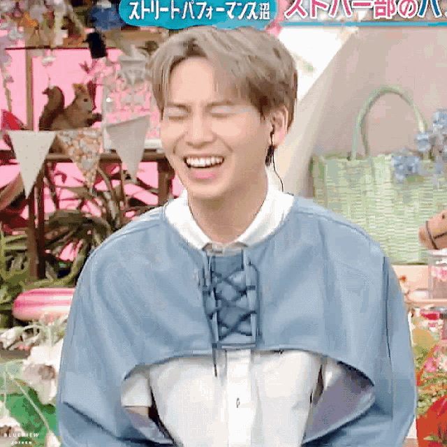 a man is laughing in front of a sign that says ' ストリート パフォーマンス '