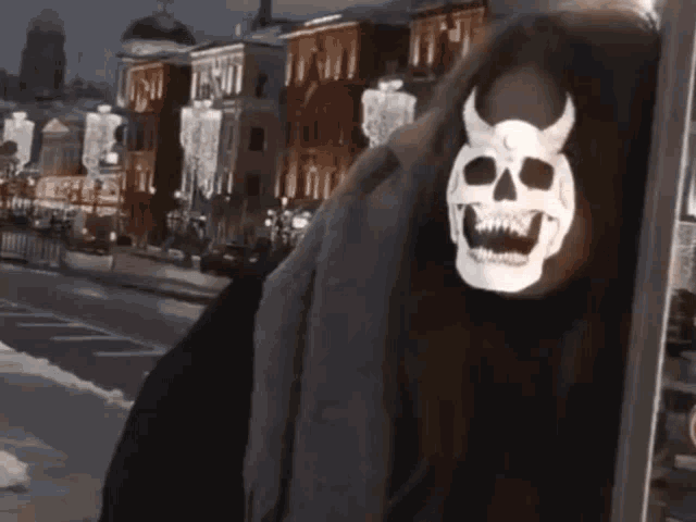 a woman wearing a skull mask with horns