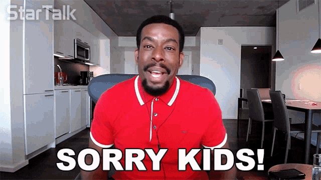 a man in a red shirt says sorry kids in front of a kitchen