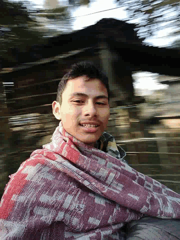 a young man wearing a red and white scarf is smiling