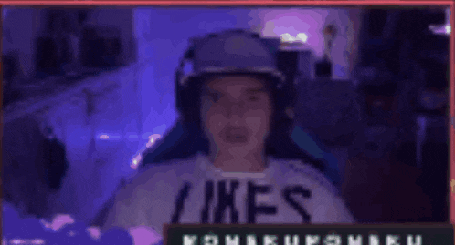 a man wearing headphones and a shirt that says likes is sitting in a chair .
