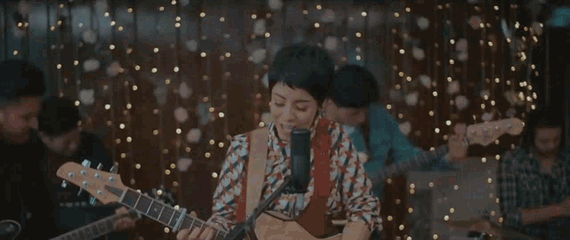 a man is playing a guitar in front of a crowd while confetti is falling around him
