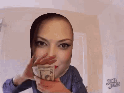 a woman is holding a 20 dollar bill in front of her face ..