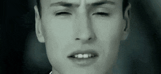 a black and white photo of a man 's face with his eyes closed .