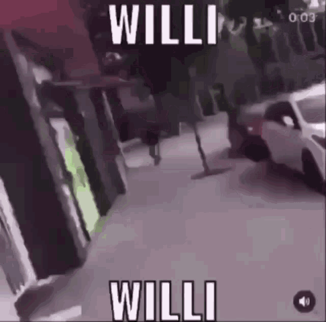 a man is walking down a sidewalk next to a car with the word willi on it .