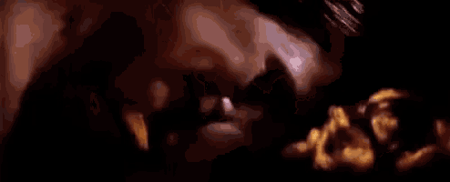 a close up of a person 's face with flames coming out of it in a dark room .