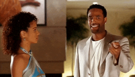 a man and a woman are standing next to each other and the man is pointing at the woman .