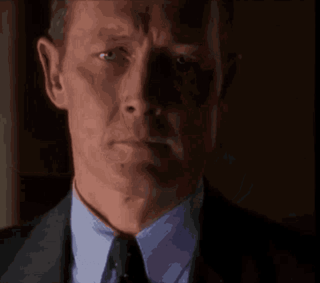 a man in a suit and tie is looking down