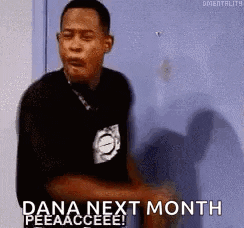a man is standing in front of a blue door and saying `` dana next month ! ''