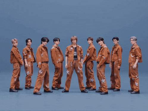 a group of young men standing next to each other wearing brown outfits with stars on them