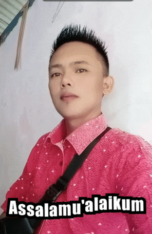 a man wearing a pink shirt with the words assalamu ' alaikum written on it