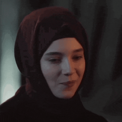 a woman wearing a hijab is smiling and looking at the camera .