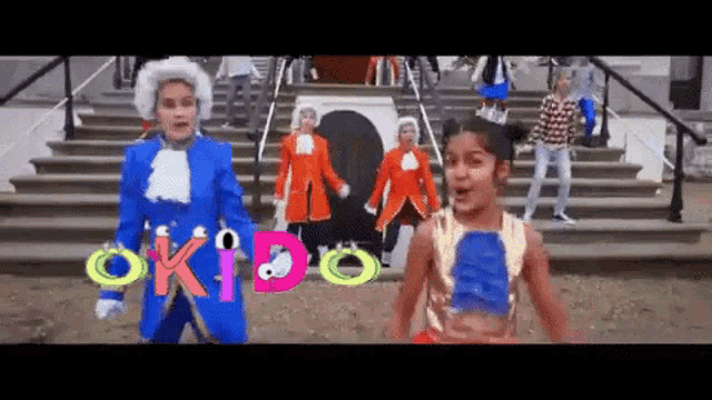 a group of people are dancing in front of a sign that says okido on it