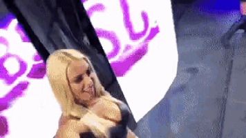 a woman is standing in front of a purple and white sign that says ' sd '