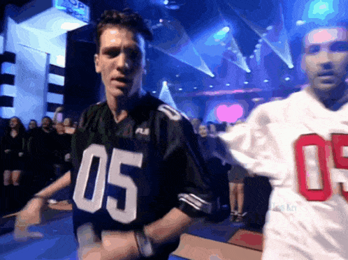 a man wearing a jersey with the number 05 on it stands in front of a crowd