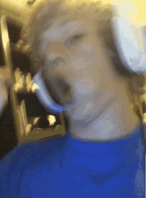 a blurry picture of a person wearing headphones and a blue shirt