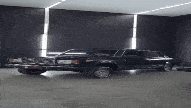 a black car with white tires is parked in a dark room