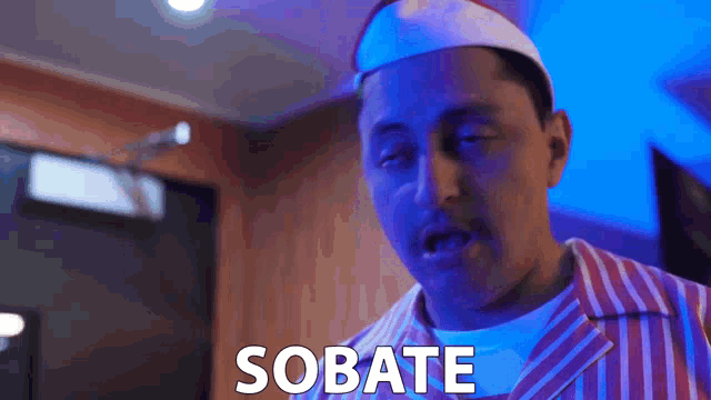 a man in a striped shirt says sobate in front of a blue light
