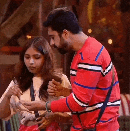 a man and a woman are standing next to each other .