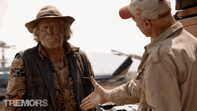 a man in a cowboy hat is shaking hands with another man in a trenors ad