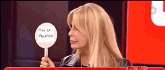 a woman is holding a sign that says " paso la palabra " on it