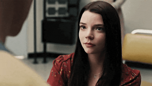 a woman in a red shirt is looking at a man