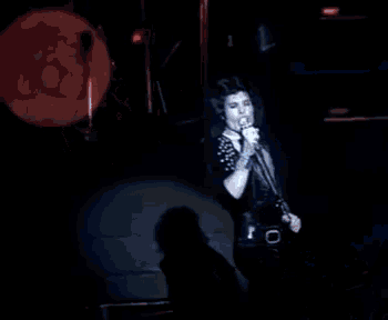 a woman singing in front of a drum set with the letter q on it
