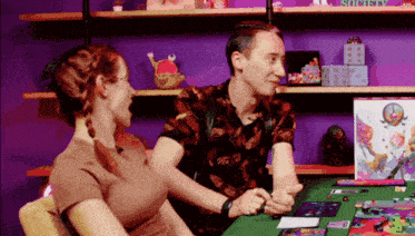 a man and a woman are holding hands in front of a shelf with a box that says sorcery on it