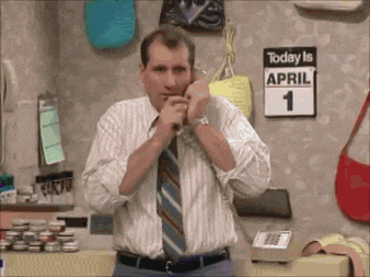 a man adjusts his tie in front of a sign that says today is april 1st