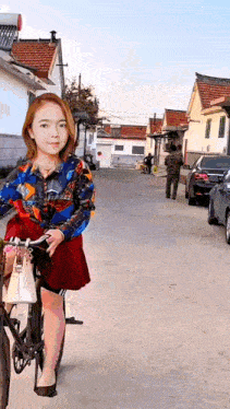a woman is riding a bicycle down a street with cars parked behind her